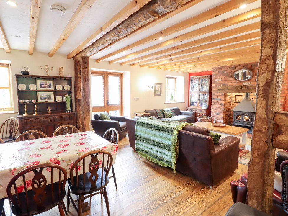 A living room and dining area with a fireplace at Ysgubor Pwlliago Pennant Valley near Llangynog