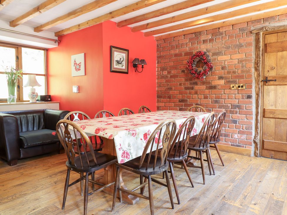 A dining room with a wooden table and chairs at Ysgubor Pwlliago in Pennant Valley near Llangynog
