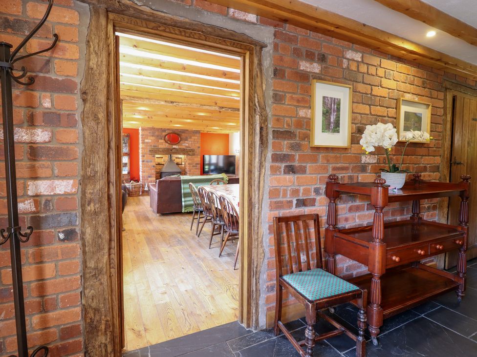A hallway with a wooden shelf and chair at Ysgubor Pwlliago, Pennant Valley near Llangynog
