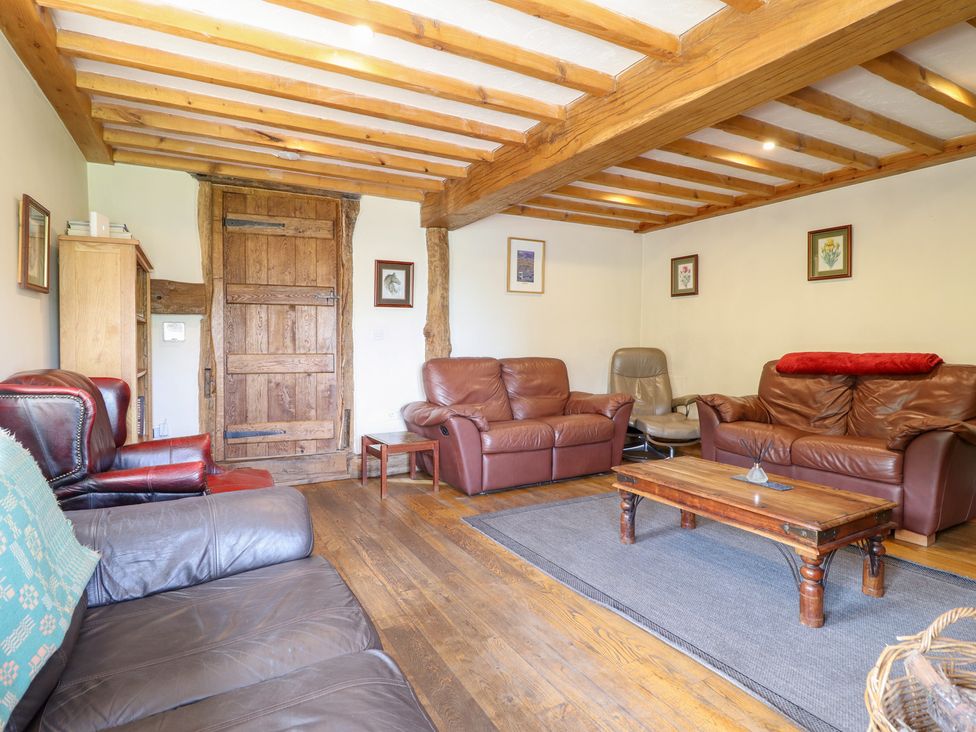 A living room with sofas and a wooden coffee table at Ysgubor Pwlliago in Pennant Valley near Llangynog