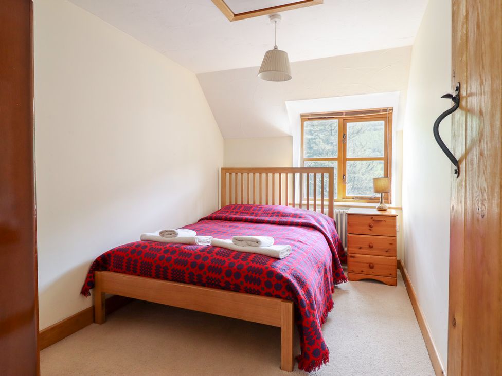 A bedroom with a bed and bedside table at Ysgubor Pwlliago Pennant Valley near Llangynog