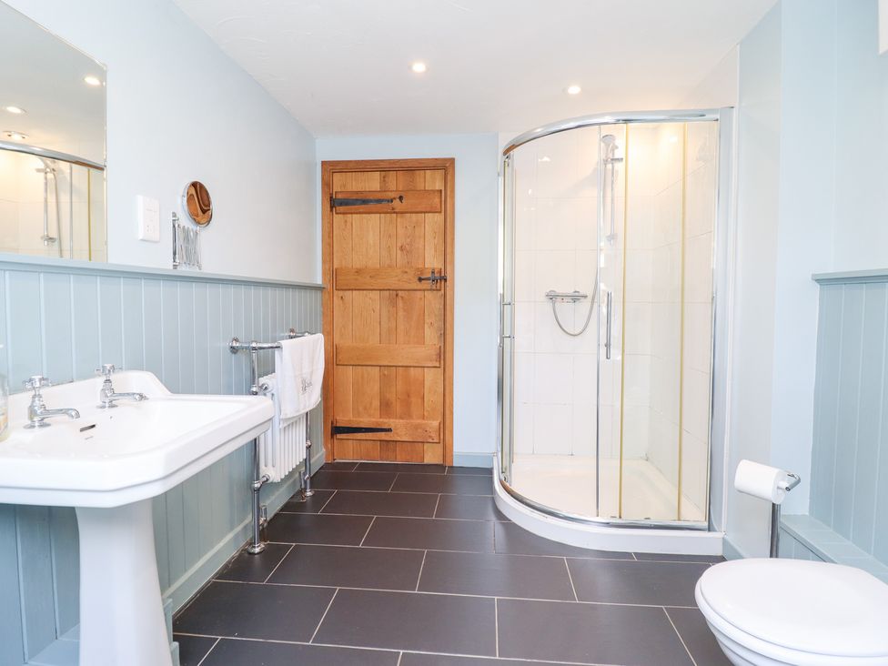A bathroom with a shower, sink and toilet at Ysgubor Pwlliago, Pennant Valley near Llangynog