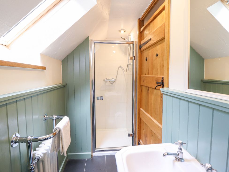 A bathroom with a shower, sink, and towel rail at Ysgubor Pwlliago, Pennant Valley near Llangynog