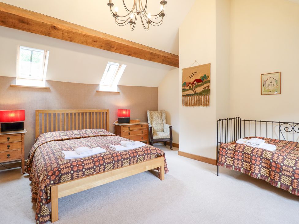A bedroom with a double bed and a single bed at Ysgubor Pwlliago in Pennant Valley near Llangynog