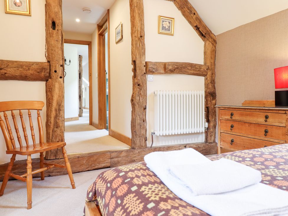 A bedroom with a chair and dresser at Ysgubor Pwlliago in Pennant Valley near Llangynog