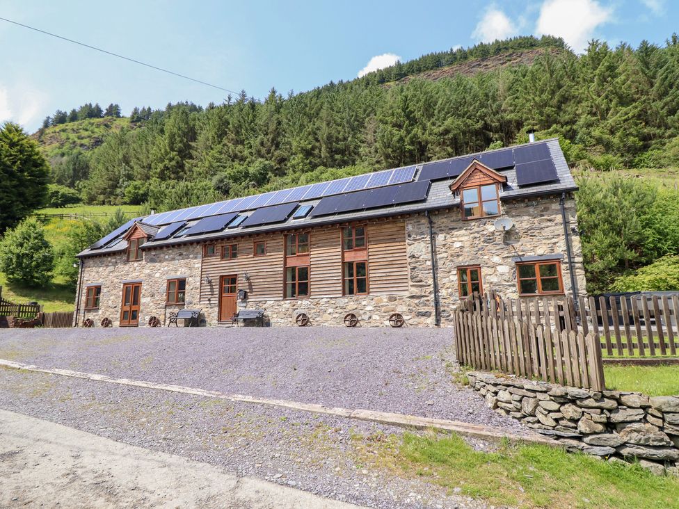 A stone building with solar panels in a scenic outdoor location at Ysgubor Pwlliago Pennant Valley near Llangynog