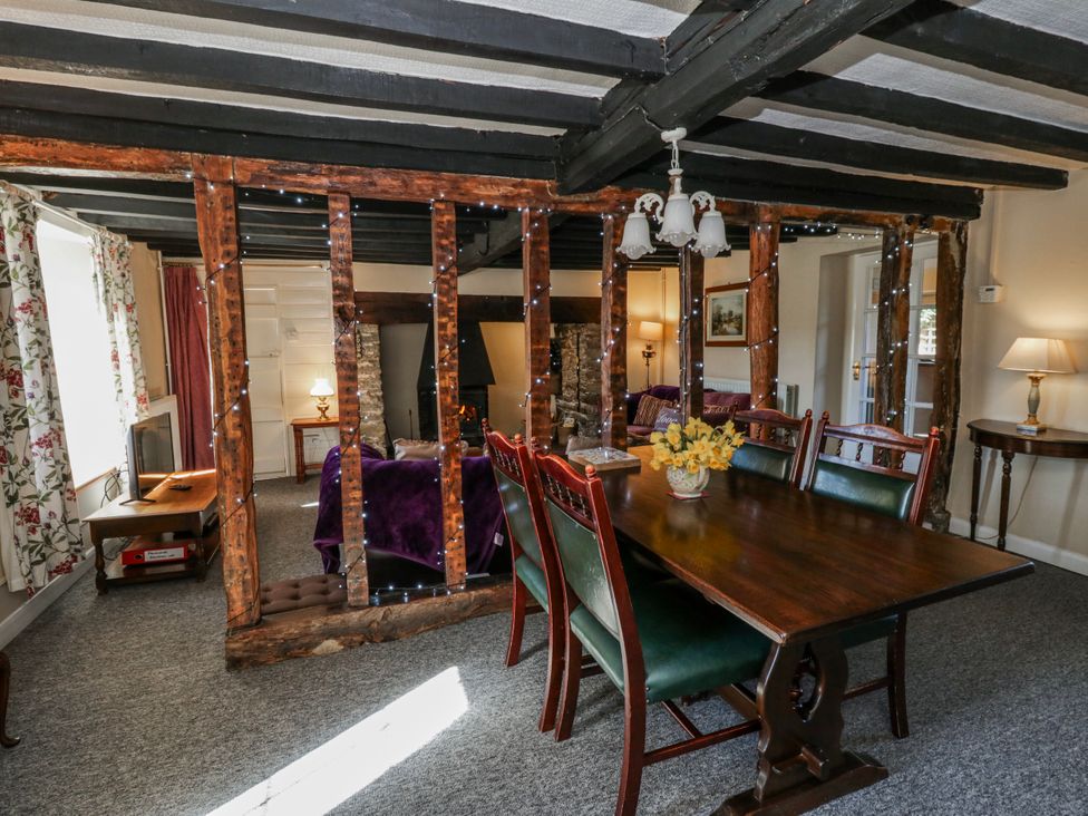 A dining room with a wooden table and chairs at Penlone Cottage in Rhayader
