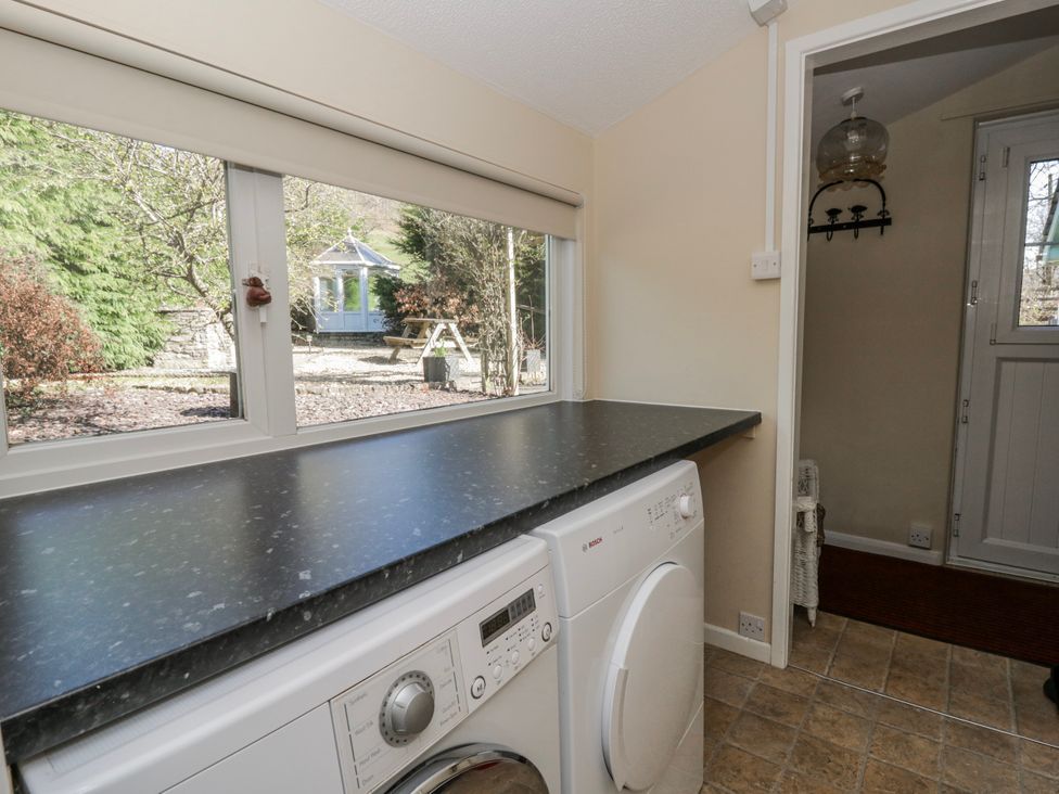 A utility room with a washing machine and counter at Penlone Cottage Rhayader