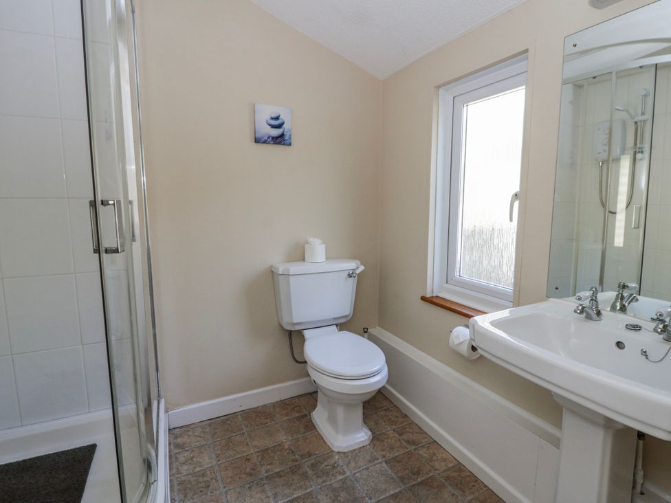 A bathroom with a shower, toilet and sink at Penlone Cottage in Rhayader