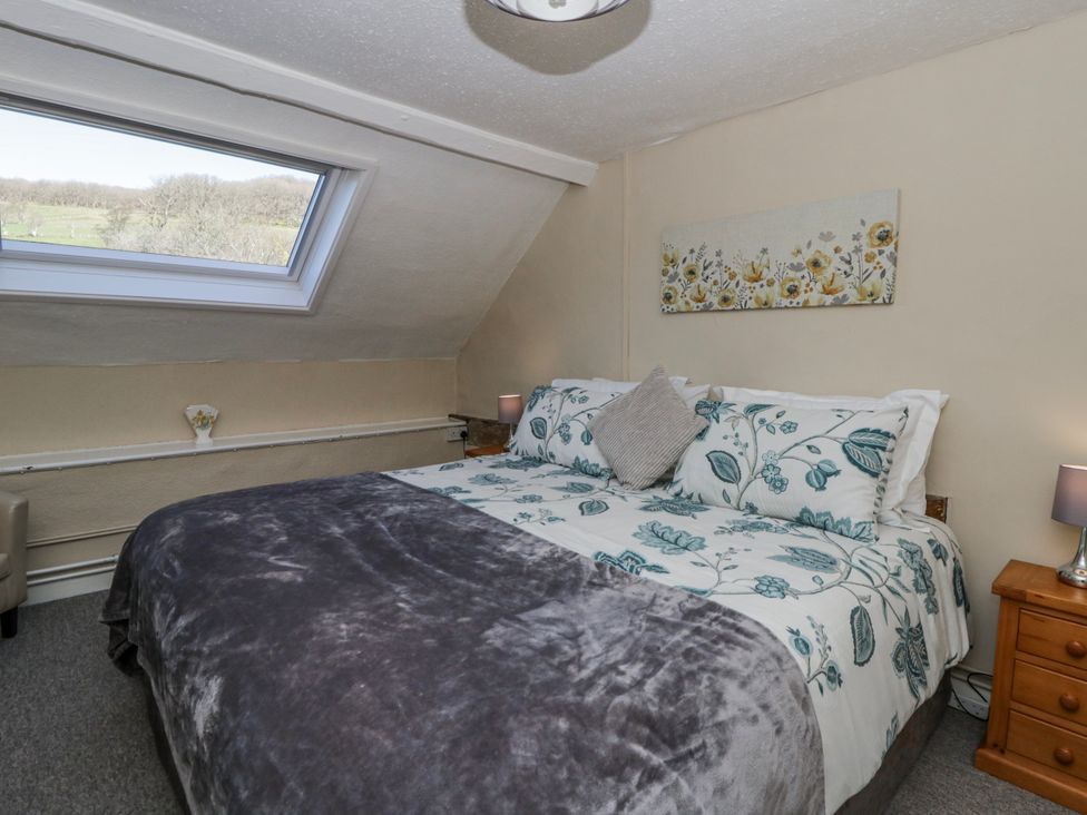 A bedroom with a double bed and a window at Penlone Cottage Rhayader