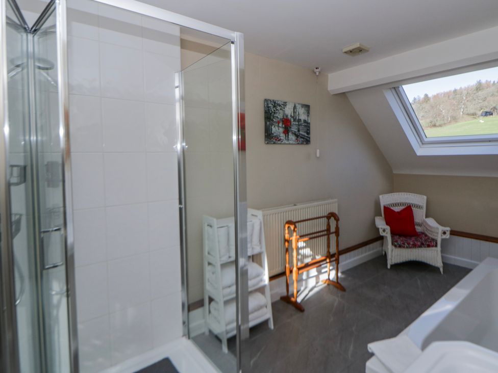 A bathroom with a shower and a bathtub at Penlone Cottage in Rhayader