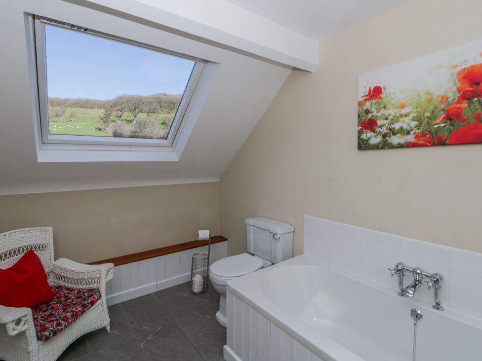A bathroom with a bathtub and a toilet at Penlone Cottage in Rhayader