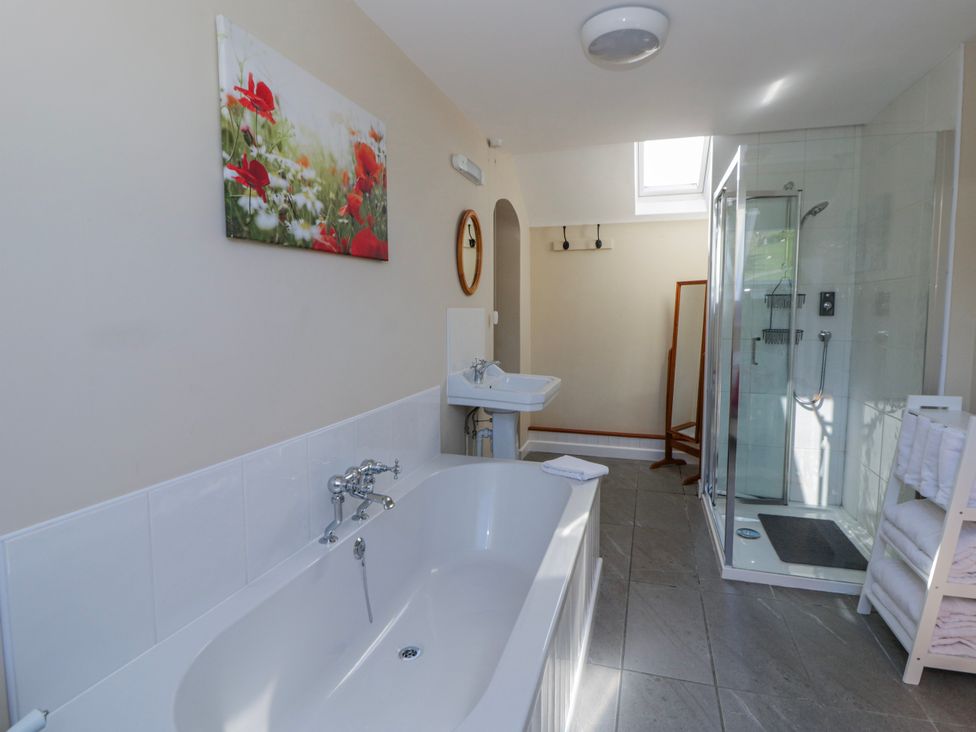 A bathroom with a bathtub and shower at Penlone Cottage in Rhayader