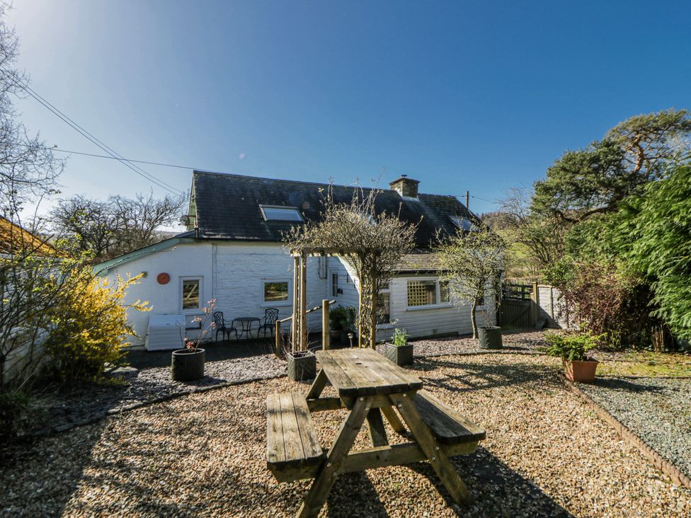 A garden with a picnic table and planters at Penlone Cottage in Rhayader