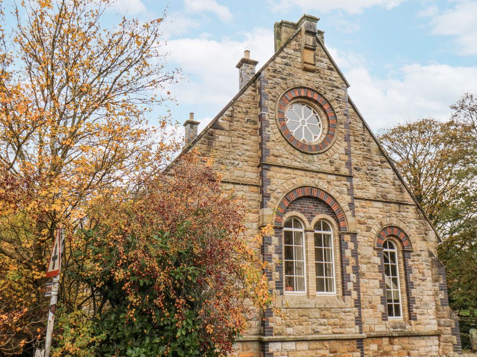 A stone building with windows and surrounding trees at 1 The Old Methodist Chapel Rosedale Abbey