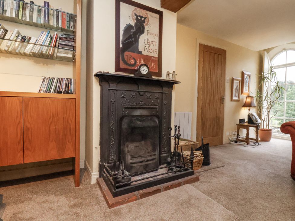 A living room with a fireplace and bookshelf at 1 The Old Methodist Chapel Rosedale Abbey