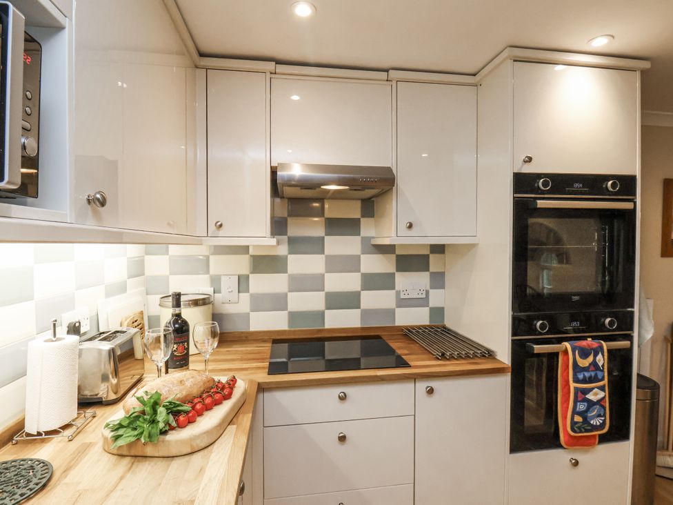 A kitchen with cabinets, oven, stove, and countertop items at 1 The Old Methodist Chapel Rosedale Abbey
