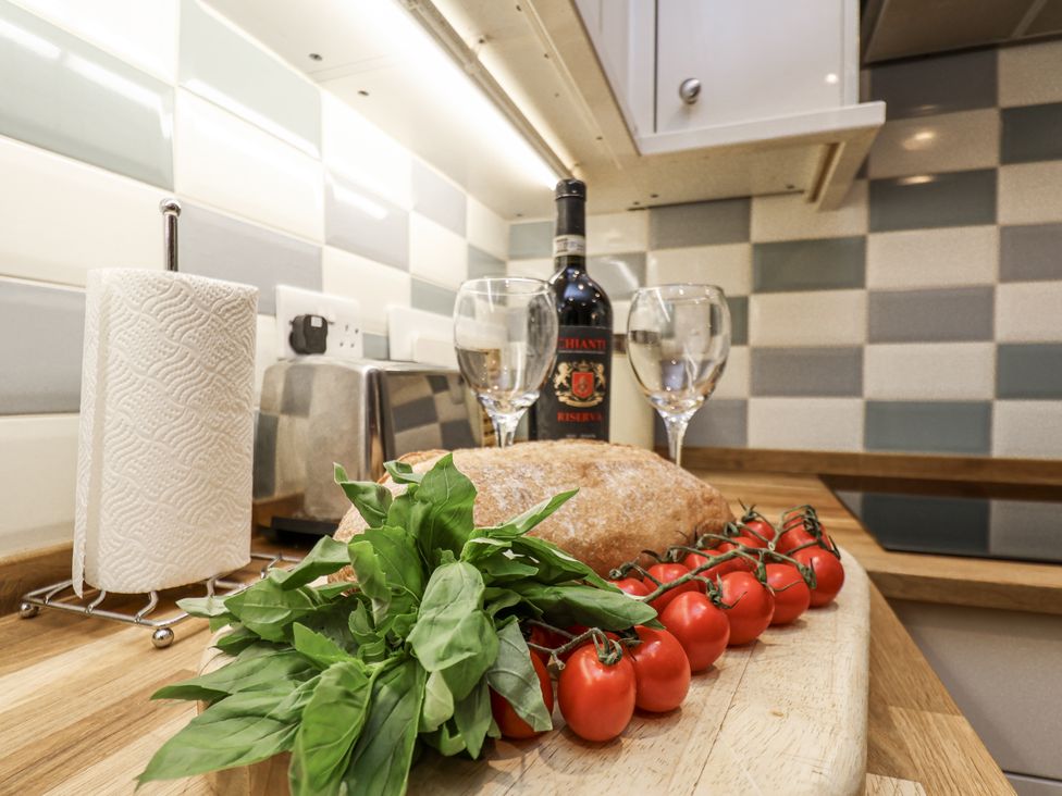 A kitchen counter with bread, wine, and vegetables at 1 The Old Methodist Chapel Rosedale Abbey