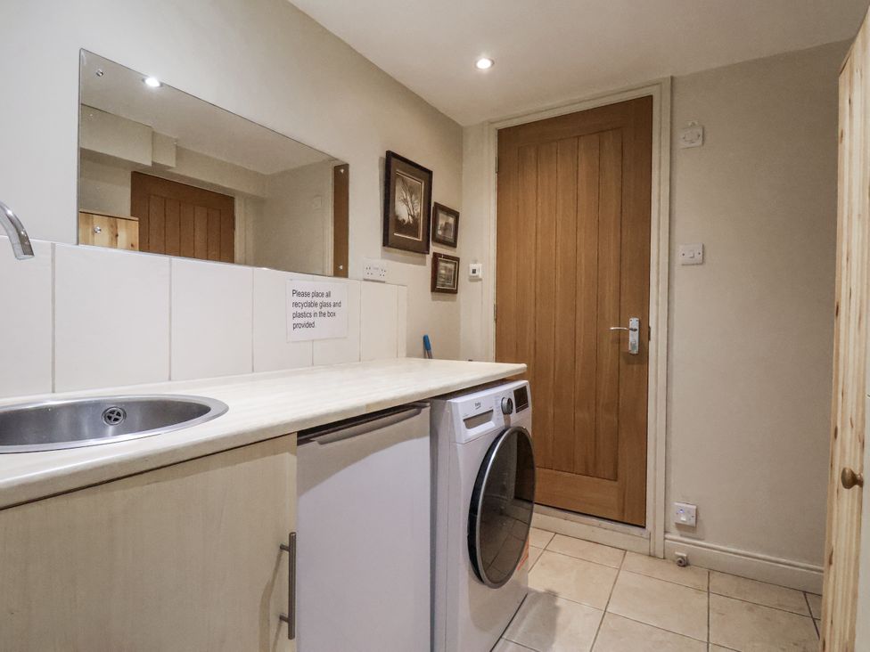 A laundry room with a washing machine and sink at 1 The Old Methodist Chapel in Rosedale Abbey