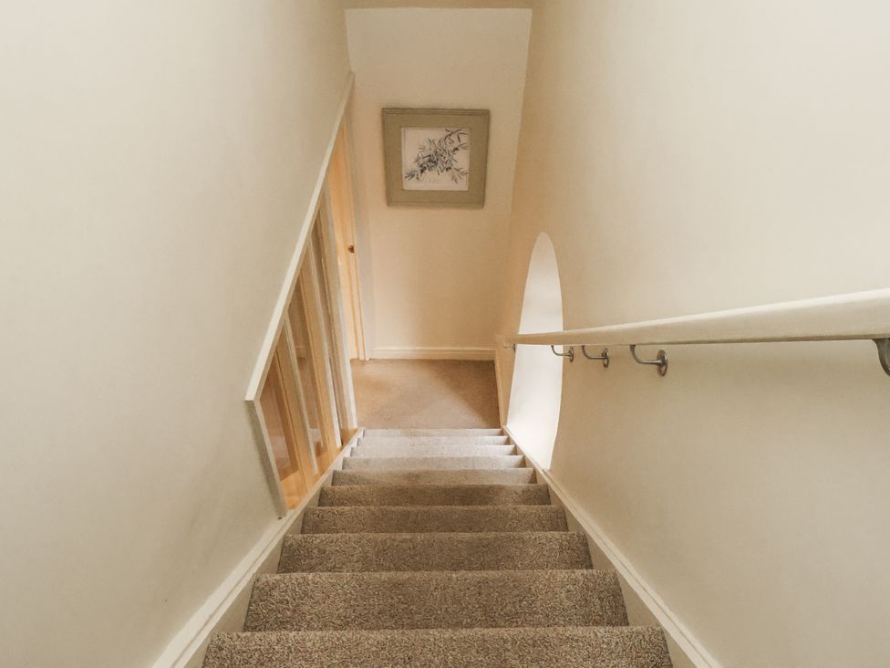 A staircase with handrail and framed artwork at 1 The Old Methodist Chapel Rosedale Abbey