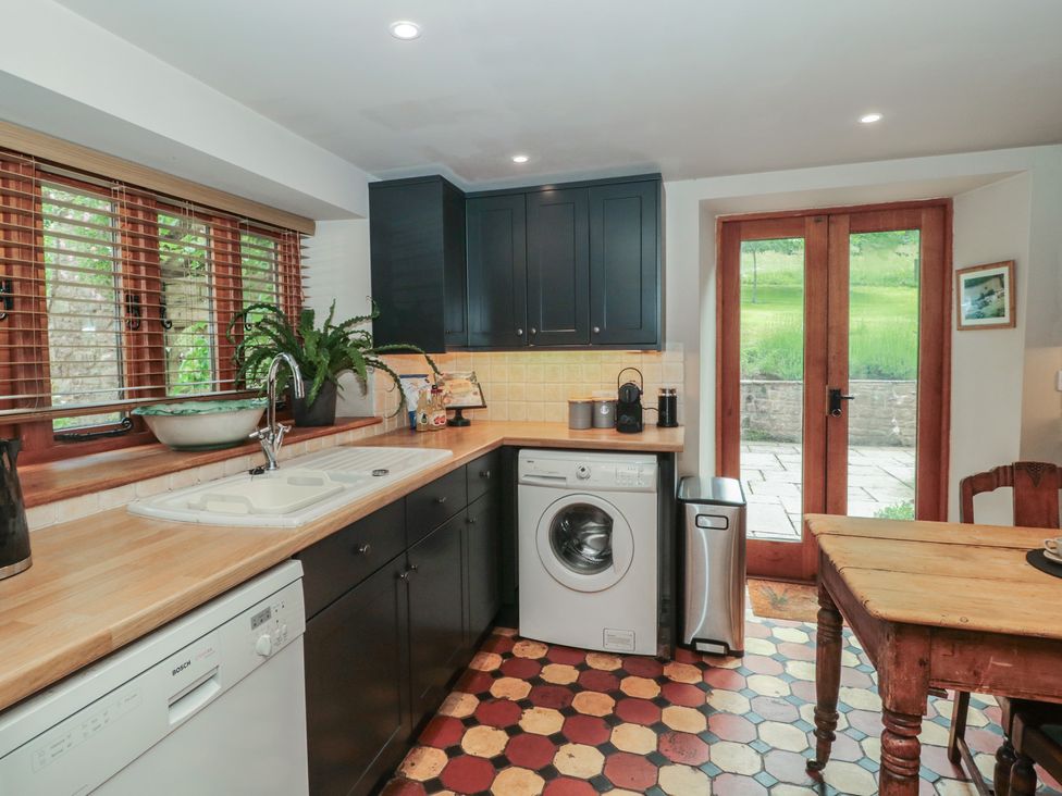 A kitchen with a sink and washing machine at The Lodge Farm Barn Deepdean near Ross-on-Wye