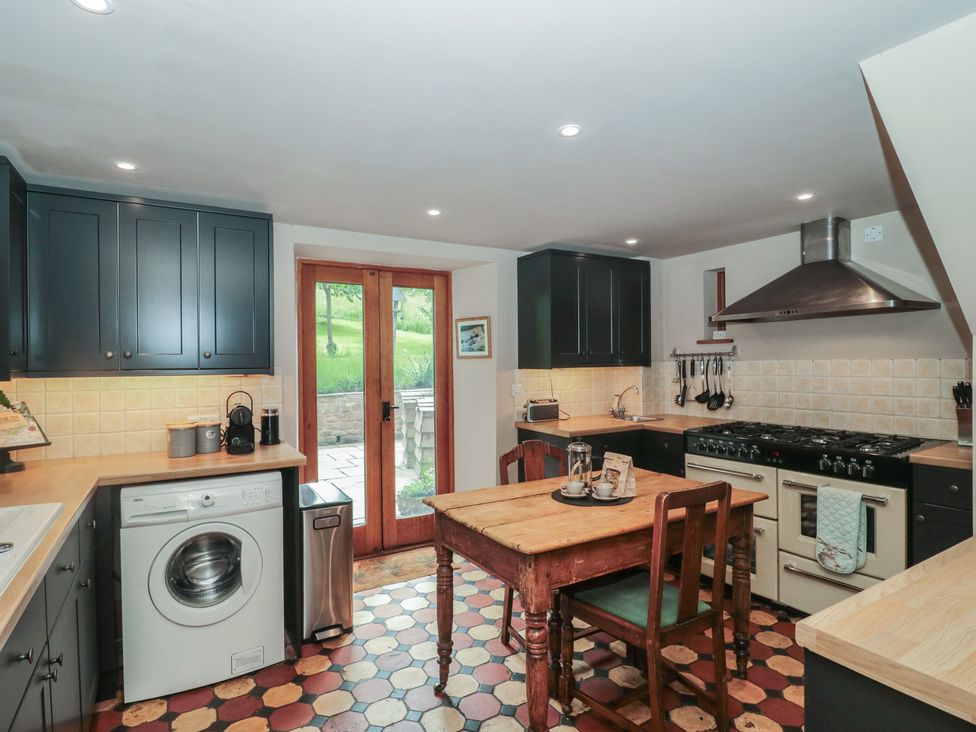 A kitchen with a table and chairs at The Lodge Farm Barn in Deepdean near Ross-on-Wye