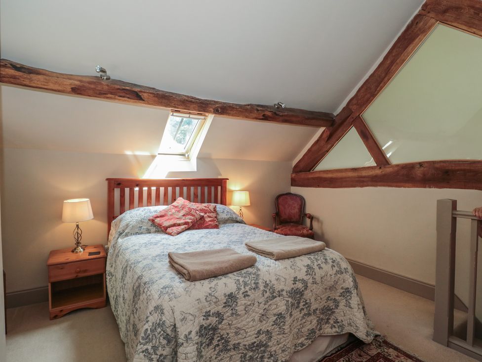 A bedroom with a bed and bedside table at The Lodge Farm Barn Deepdean near Ross-on-Wye