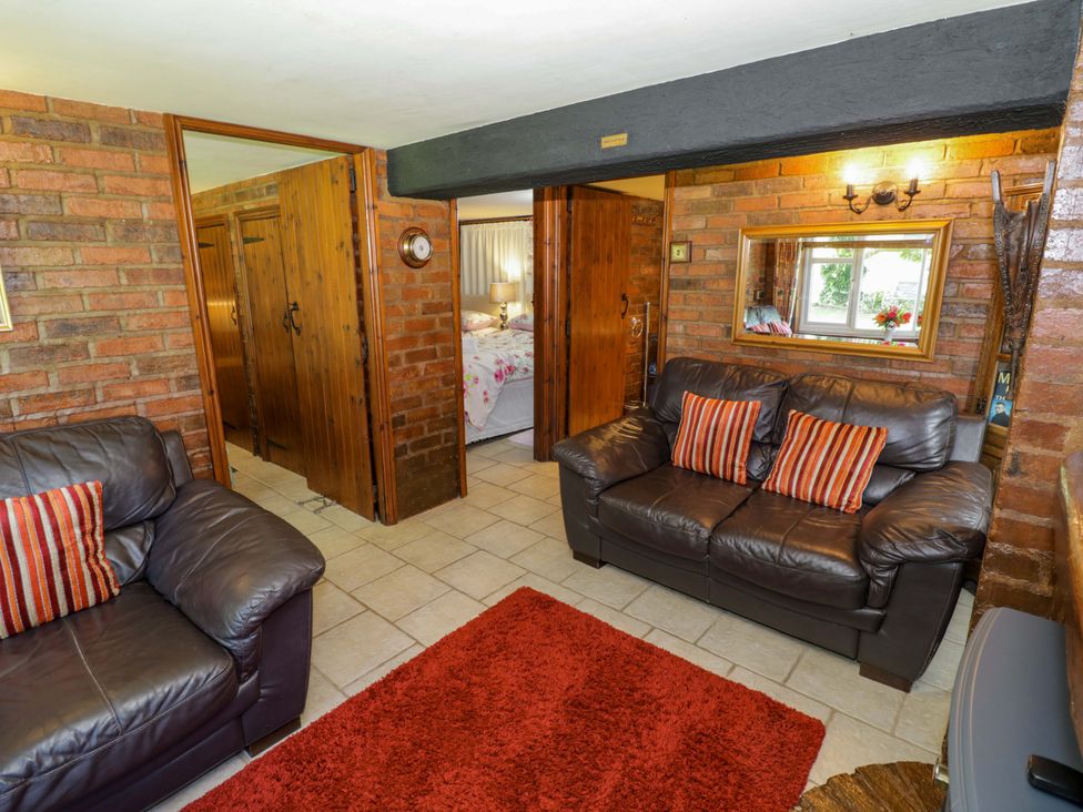 A living room with a sofa and a rug at Severn Bank Lodge in Astley Burf near Stourport-on-Severn