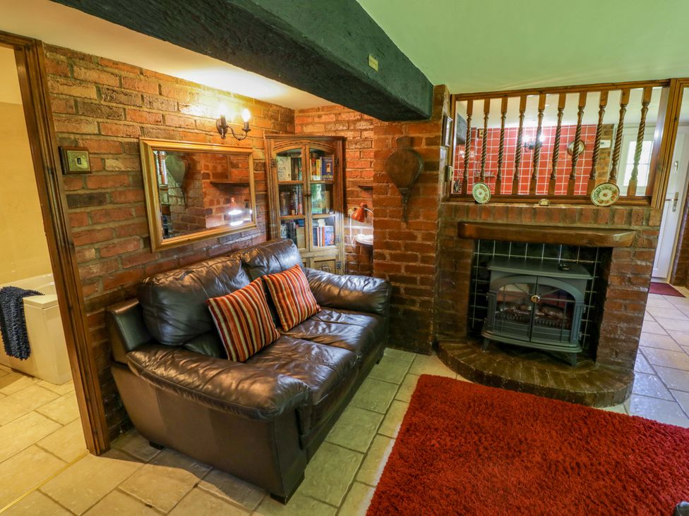 A snug with a sofa and fireplace at Severn Bank Lodge in Astley Burf near Stourport-on-Severn
