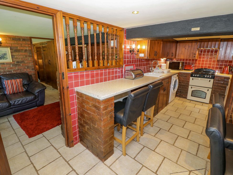 A kitchen with stools and appliances at Severn Bank Lodge Astley Burf near Stourport-on-Severn