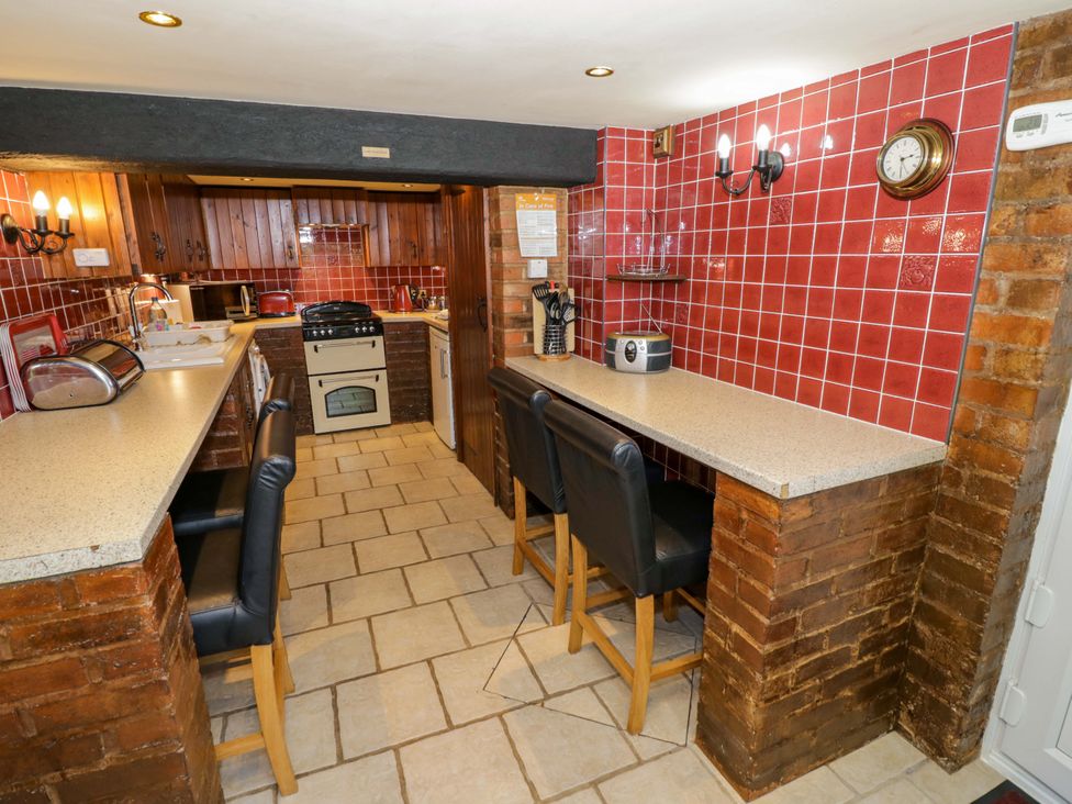A kitchen with counters and bar stools at Severn Bank Lodge in Astley Burf near Stourport-on-Severn