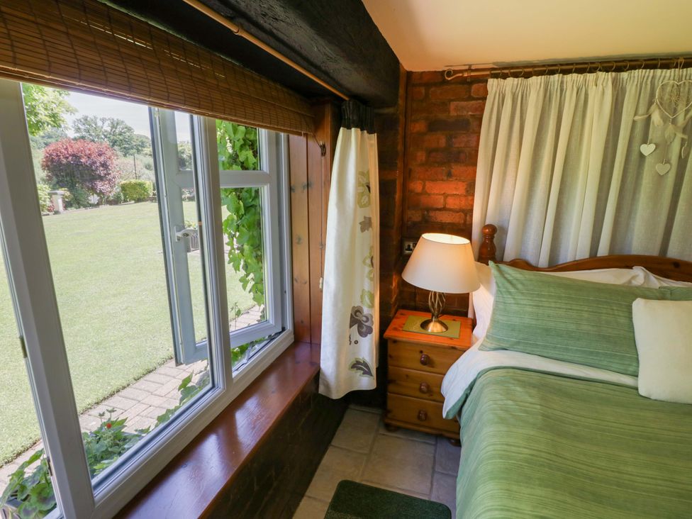 A bedroom with a bed and window at Severn Bank Lodge in Astley Burf near Stourport-on-Severn