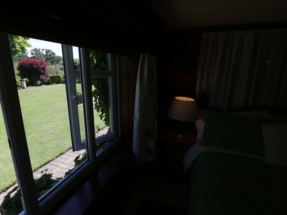 A bedroom with a window overlooking a garden at Severn Bank Lodge Astley Burf near Stourport-on-Severn