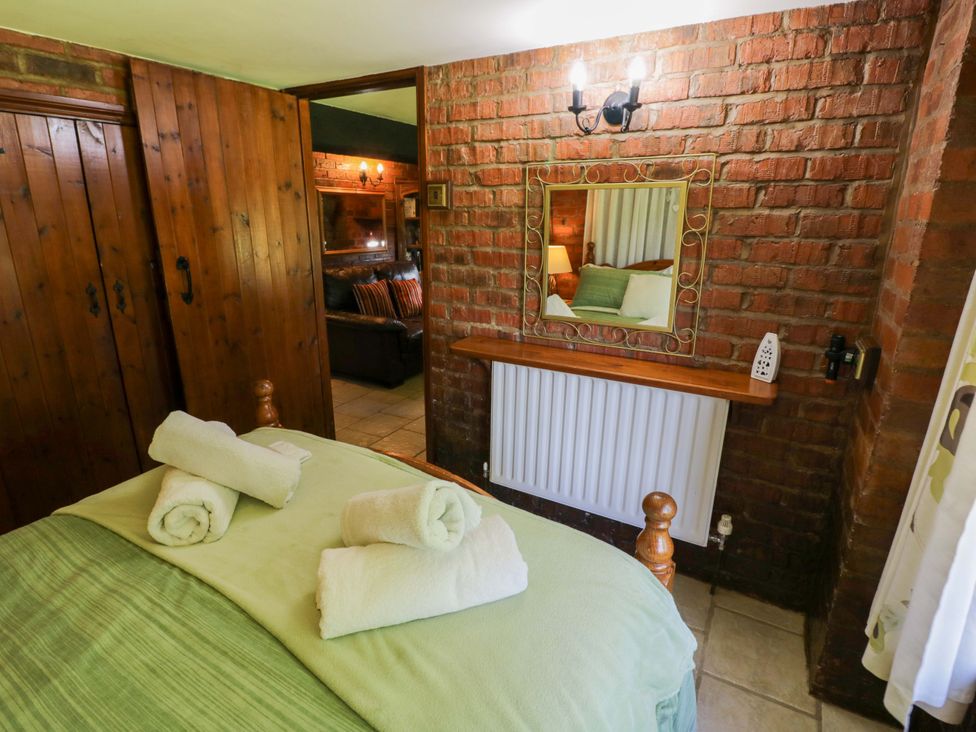 A bedroom with a bed and mirror at Severn Bank Lodge in Astley Burf near Stourport-on-Severn