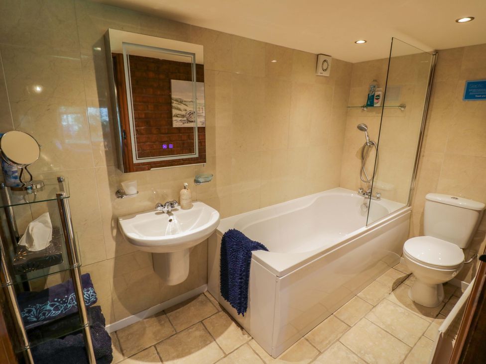 A bathroom with a bath tub, sink, and toilet at Severn Bank Lodge in Astley Burf near Stourport-on-Severn