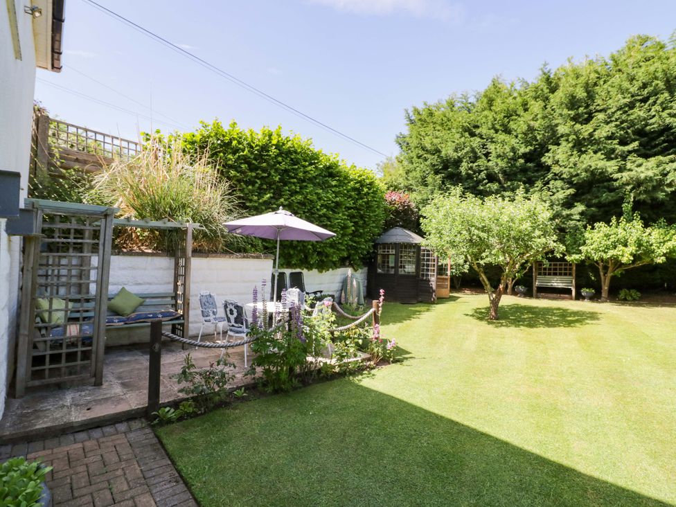 A garden with seating area and trees at Severn Bank Lodge in Astley Burf near Stourport-on-Severn