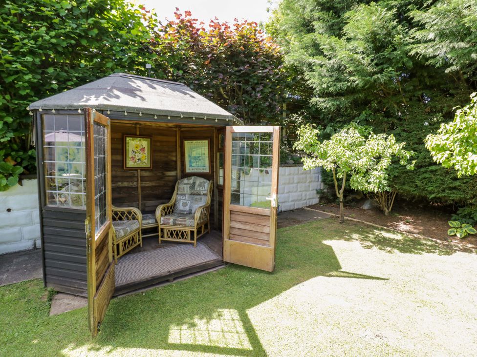 A garden shed with chairs inside at Severn Bank Lodge Astley Burf near Stourport-on-Severn