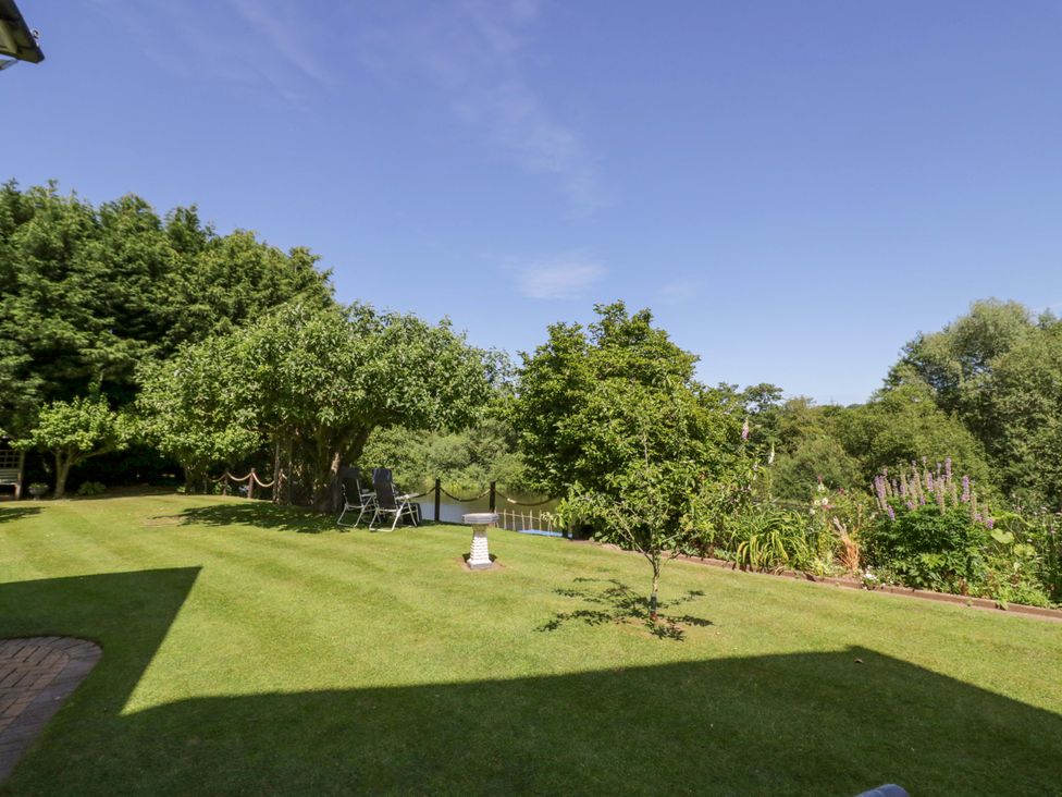 A garden with trees and lawn at Severn Bank Lodge in Astley Burf near Stourport-on-Severn