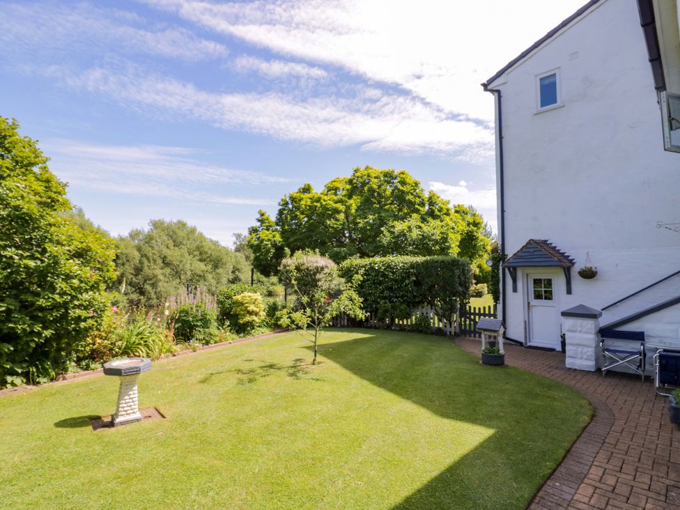 A garden with a sundial and green grass at Severn Bank Lodge Astley Burf near Stourport-on-Severn