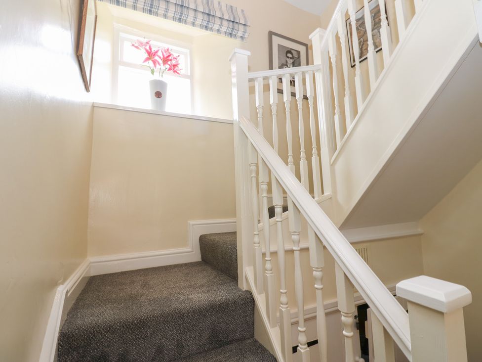 A stairway with a flower planter near a window at High Smarber in Low Row near Reeth