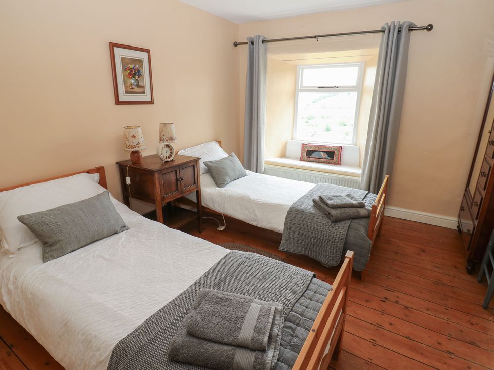 A bedroom with two beds and a window at High Smarber in Low Row near Reeth
