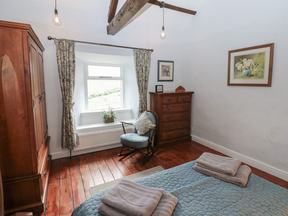 A bedroom with a bed and furniture at High Smarber in Low Row near Reeth