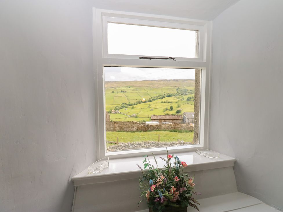A window with flowers on the sill at High Smarber in Low Row near Reeth