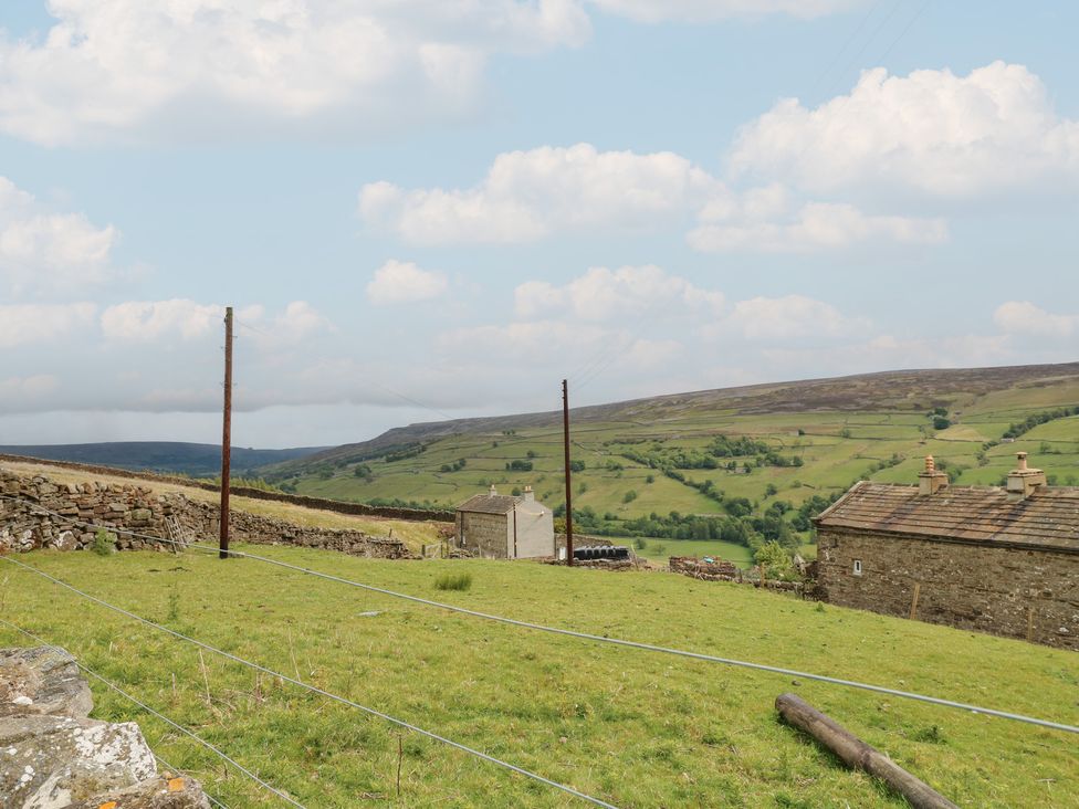 A landscape with grass and buildings at High Smarber in Low Row near Reeth