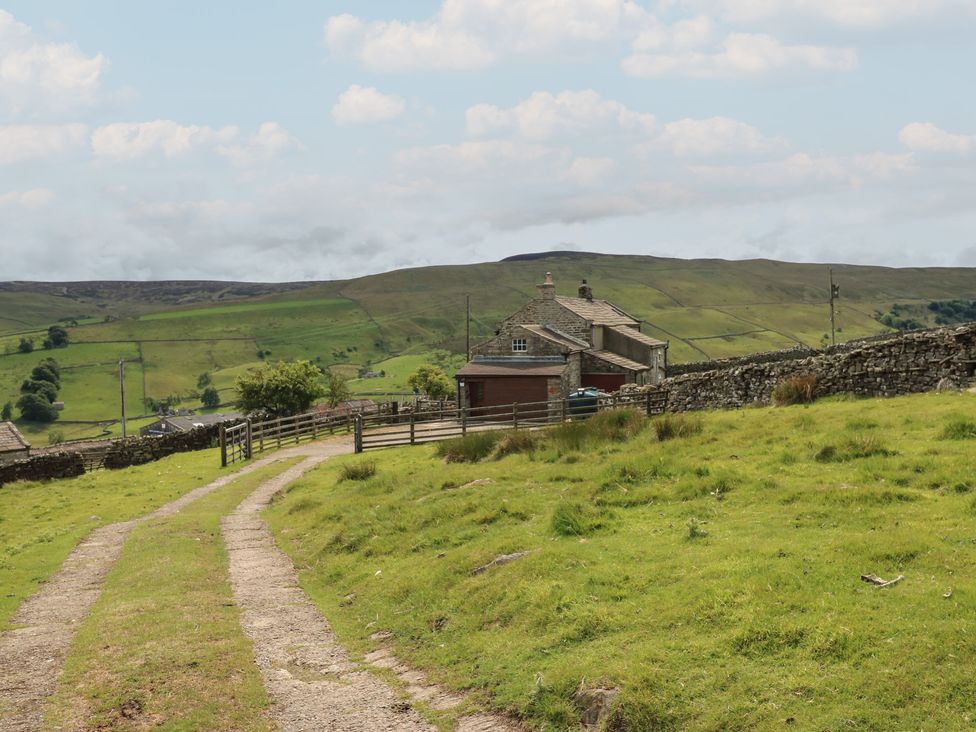 A house and dirt path in a rural area at High Smarber in Low Row near Reeth