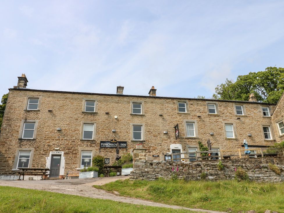 A building exterior with a sign at the Punch Bowl Inn in Low Row near Reeth