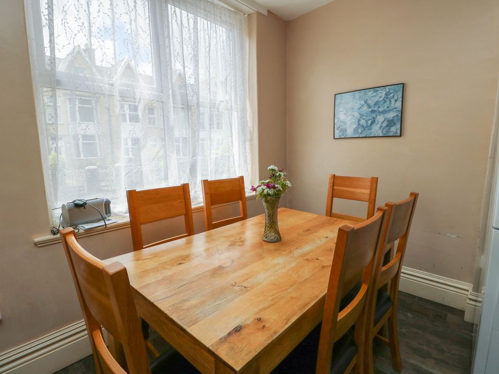 A dining room with a wooden table and chairs at Halford Hill in Llanberis