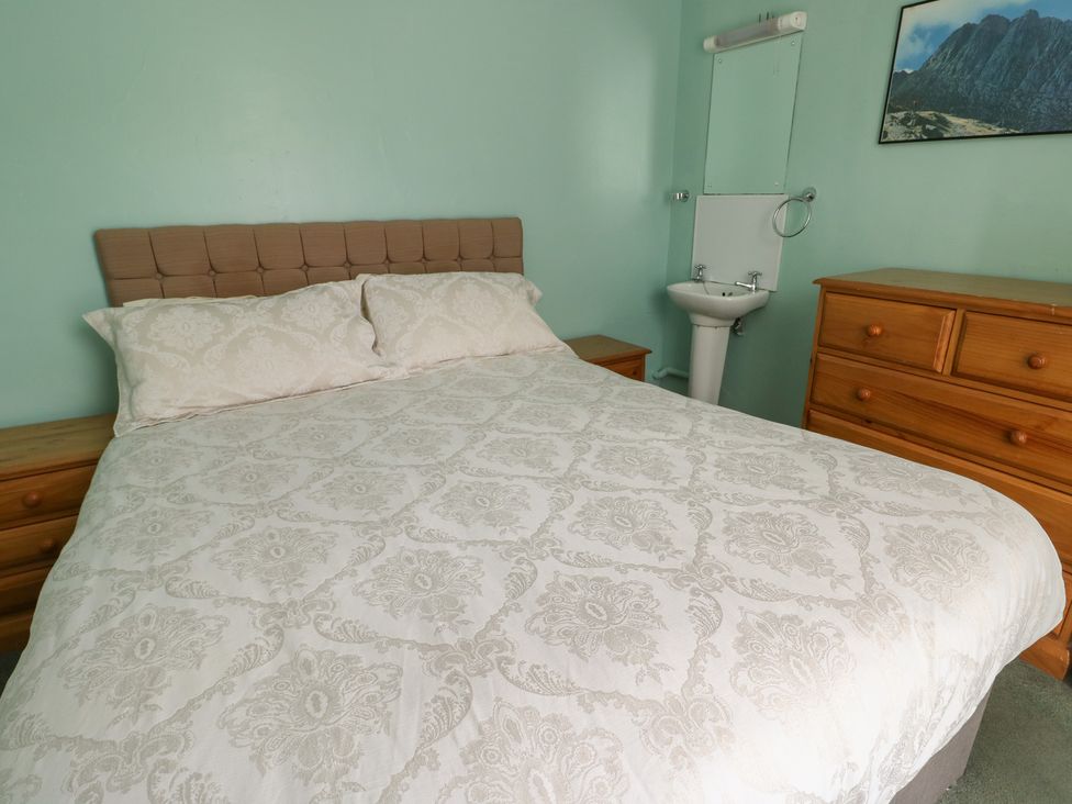 A bedroom with a bed and dresser at Halford Hill in Llanberis