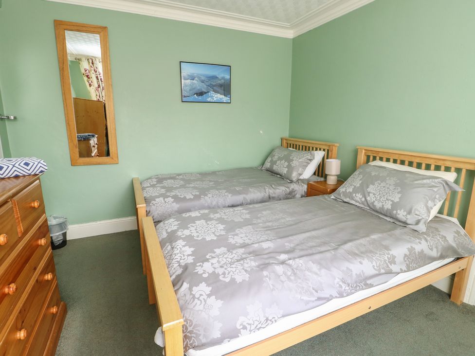 A bedroom with two beds and a dresser at Halford Hill in Llanberis