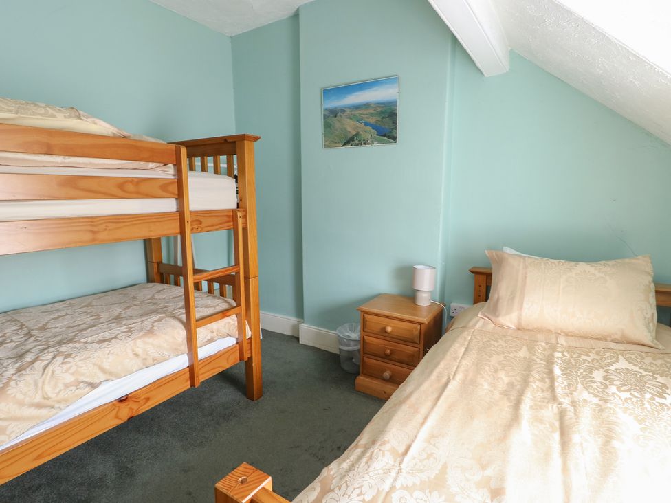 A bedroom with a bunk bed and a single bed at Halford Hill in Llanberis